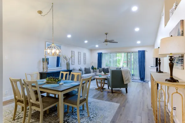 a view of a dining room with furniture a rug and wooden floor