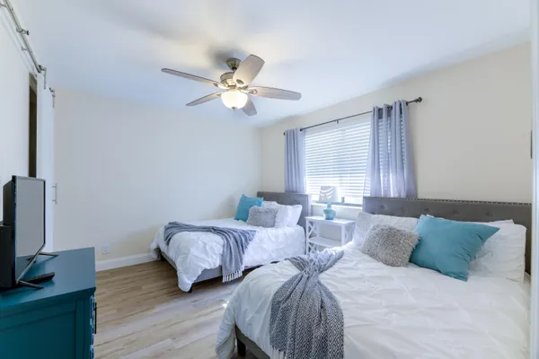 a bedroom with two beds and a flat screen tv