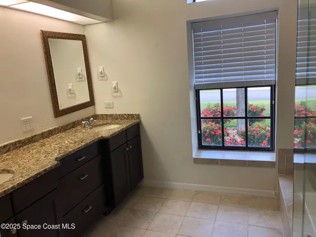 a bathroom with a granite countertop sink and a mirror