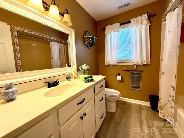 a bathroom with a double vanity sink toilet and a mirror