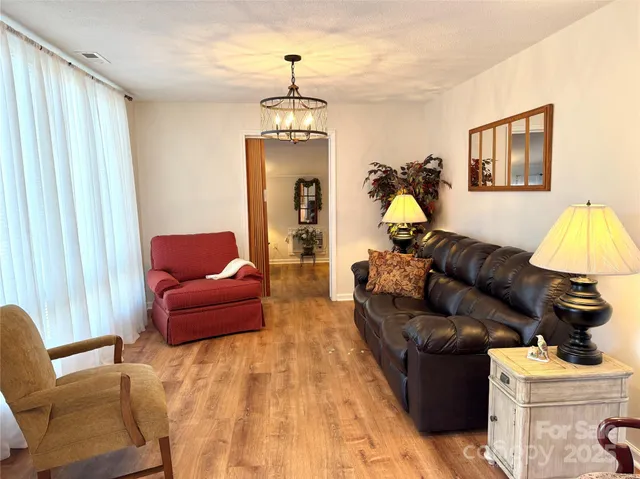 a living room with furniture a lamp and a chandelier