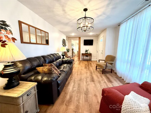 a living room with furniture and a chandelier