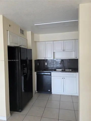 a kitchen with a refrigerator and a sink