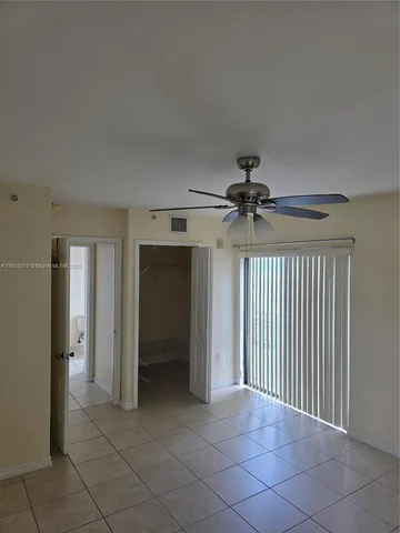 a view of a livingroom with a ceiling fan & entryway