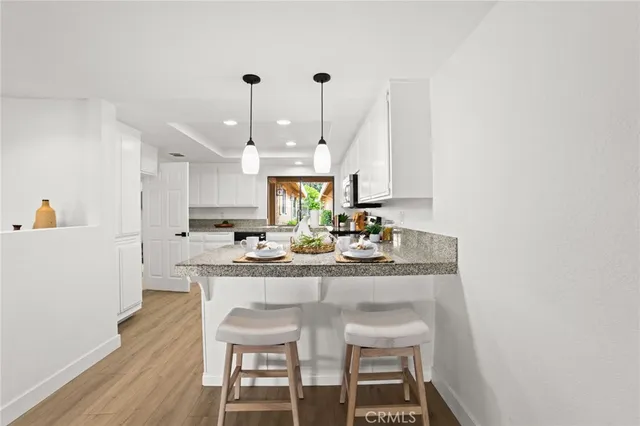 a kitchen with kitchen island stainless steel appliances a dining table and chairs