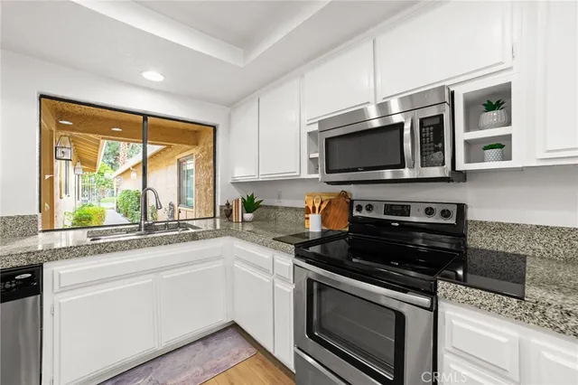 a kitchen with stainless steel appliances a stove sink microwave and cabinets