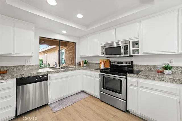 a kitchen with sink a microwave and cabinets