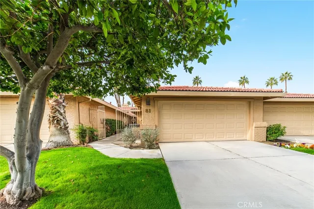 a front view of a house with a yard and a garage