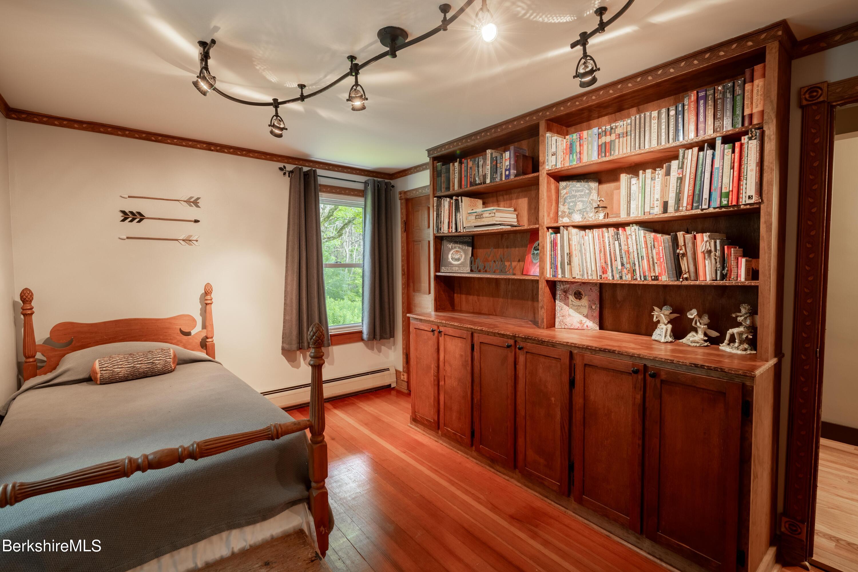 135 Ed Jones Road Otis, MA 01253 - Photo 28 of 45 a bedroom with furniture and a book shelf