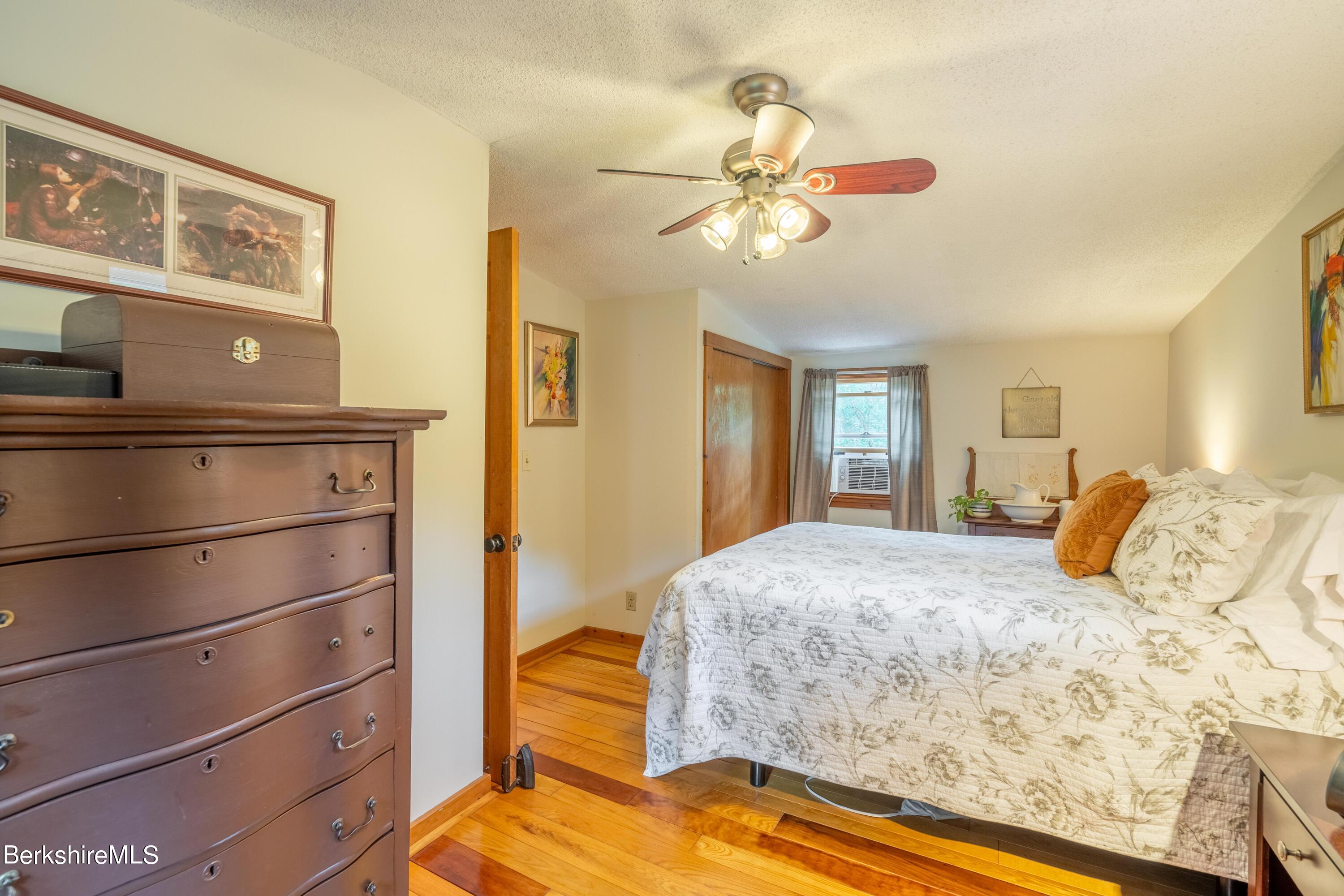 135 Ed Jones Road Otis, MA 01253 - Photo 39 of 45 a bedroom with a bed and a chandelier