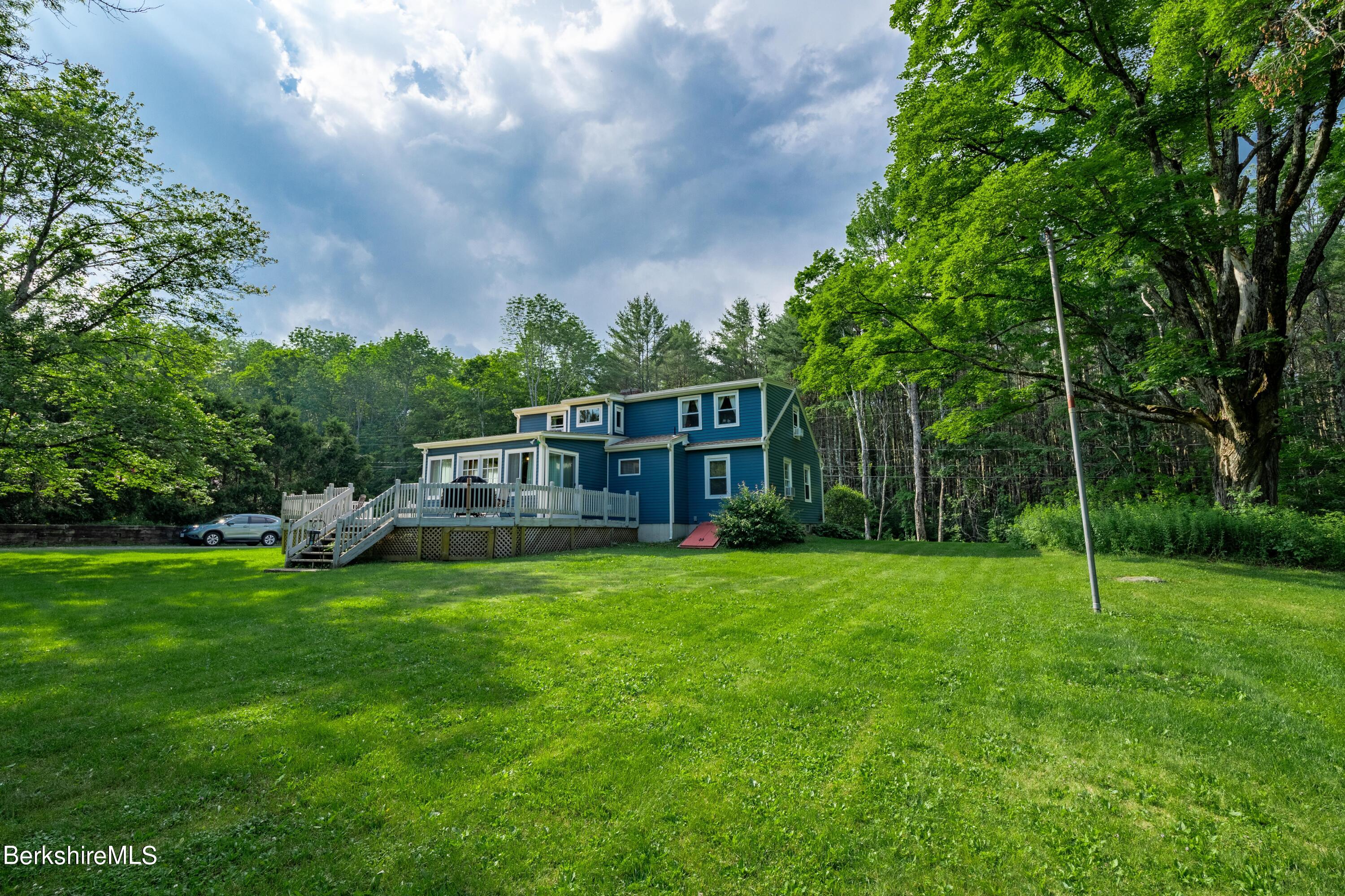 135 Ed Jones Road Otis, MA 01253 - Photo 4 of 45 a view of a house with a big yard and large trees