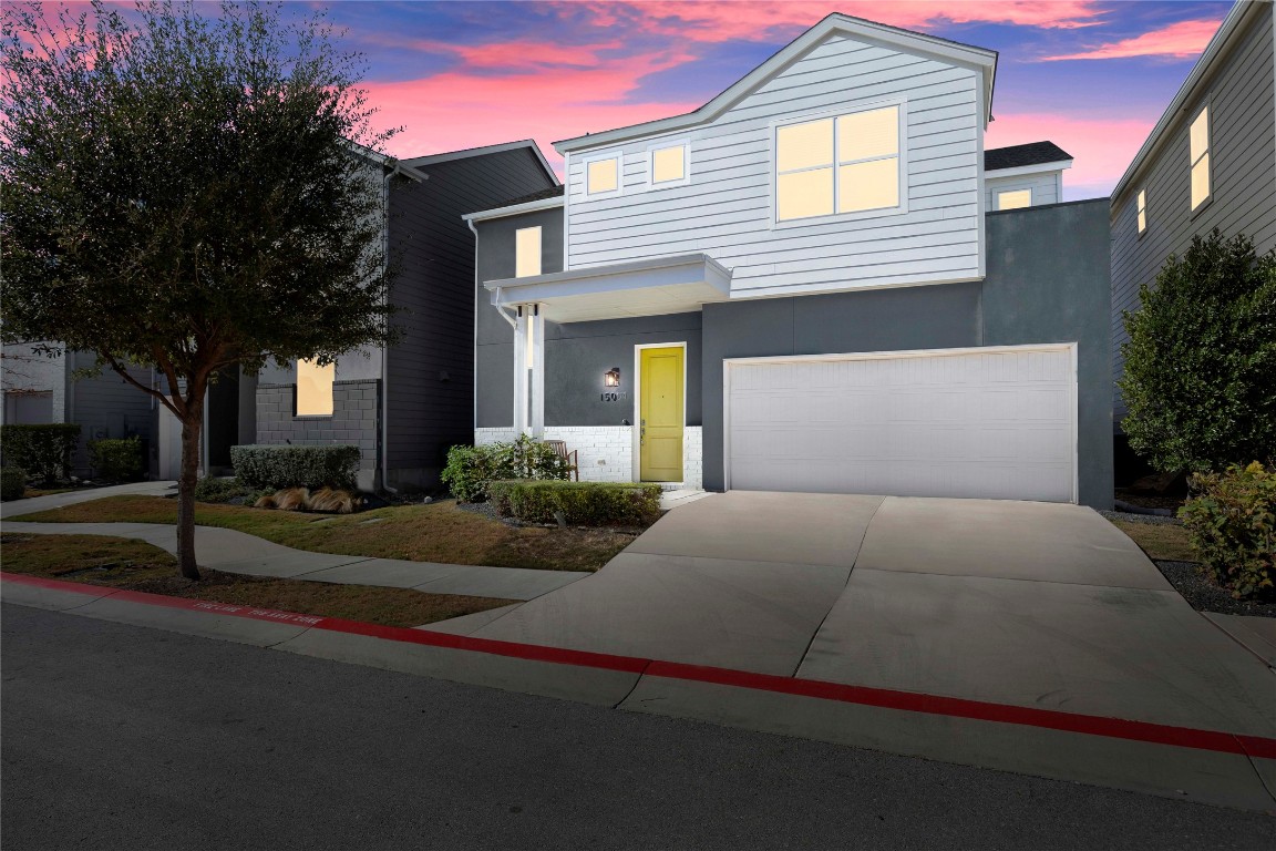 Contemporary home featuring concrete driveway, an attached garage, and stucco siding