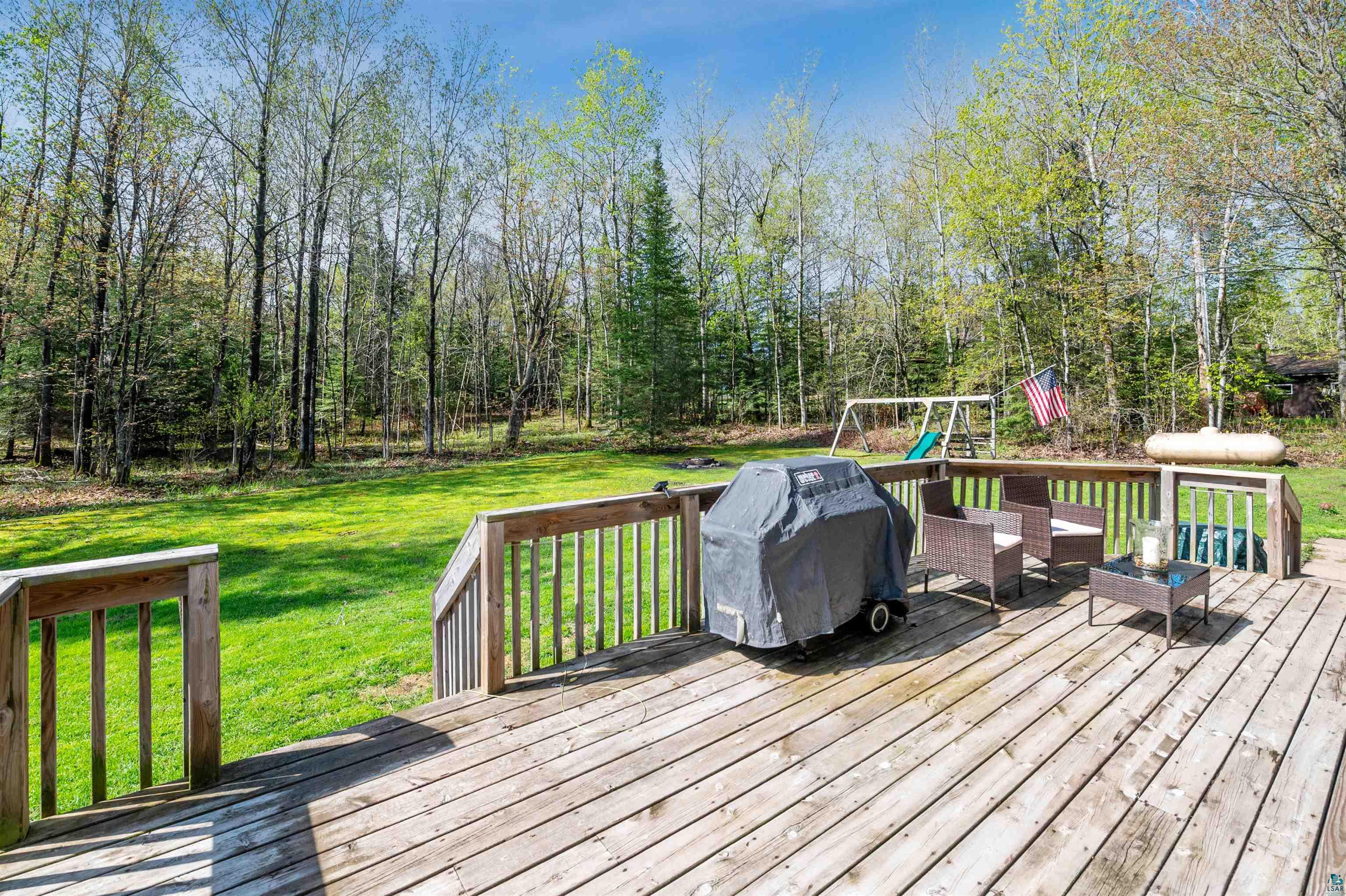 28 North Cloquet Road East Esko, MN 55733 - Photo 7 of 26 Wooden terrace with grilling area, a playground, and a lawn