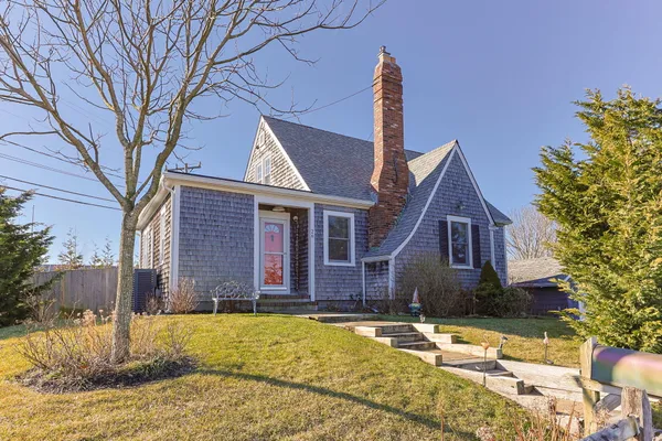 a front view of a house with a yard covered with snow