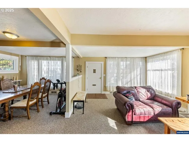 a living room with furniture a flat screen tv and a large window