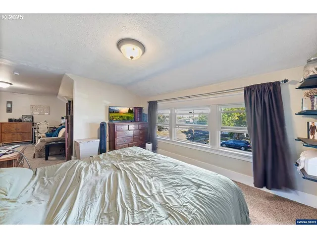 a bedroom with a bed and a large window