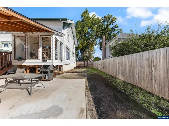 a view of a patio with table and chairs with wooden fence and plants