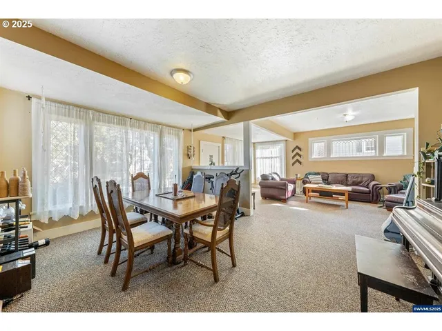 a dining room with furniture and a large window
