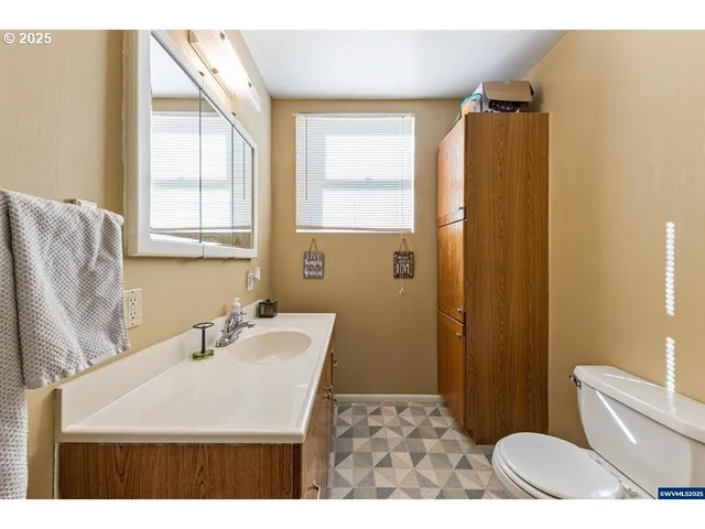 a bathroom with a sink a toilet a mirror and shower