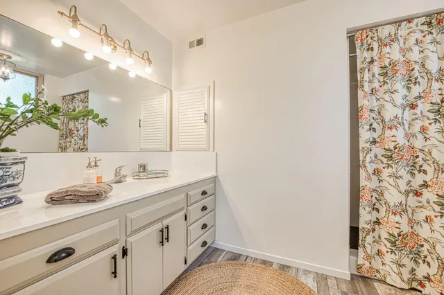 a bathroom with a granite countertop sink and a mirror