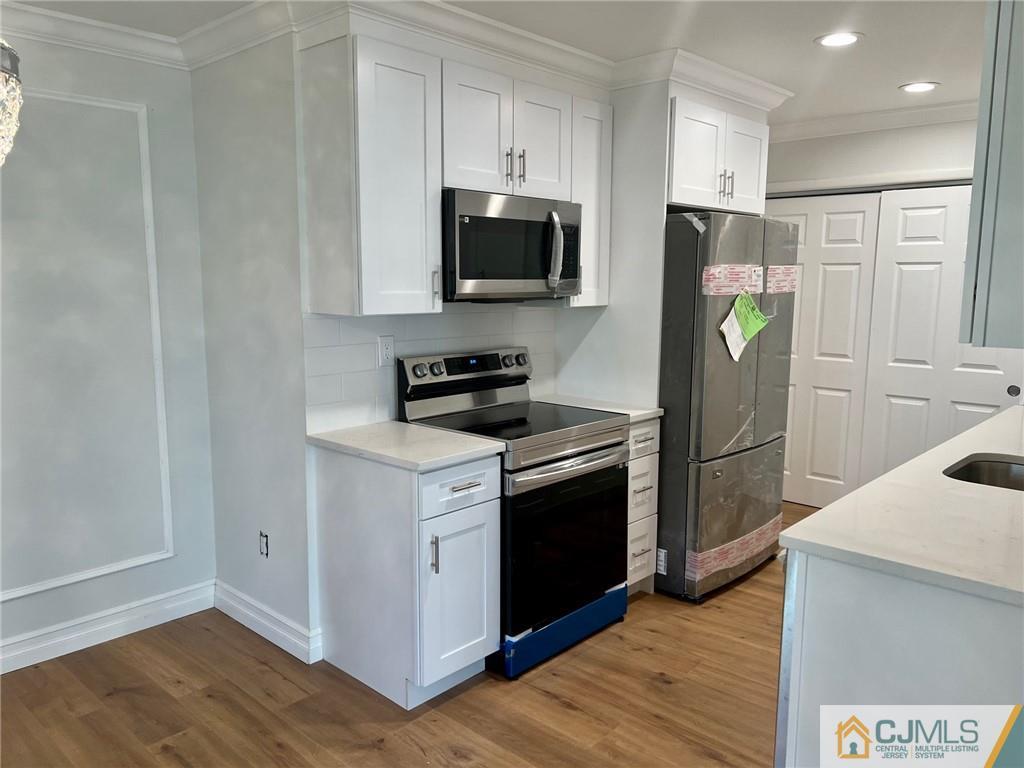 267 Glen Road, Unit 267B Monroe Township, NJ 08831 - Photo 8 of 26 a kitchen with stainless steel appliances a refrigerator stove and microwave