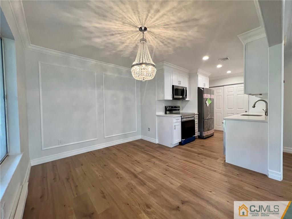 267 Glen Road, Unit 267B Monroe Township, NJ 08831 - Photo 9 of 26 a view of a kitchen with a sink wooden cabinet and a refrigerator