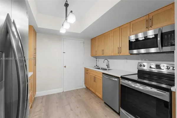 a kitchen with stainless steel appliances a sink stove and refrigerator