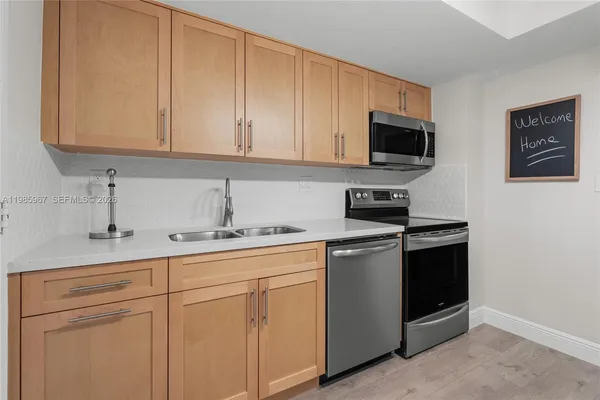 a kitchen with stainless steel appliances granite countertop white cabinets a sink and dishwasher