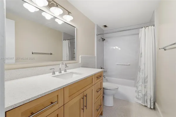 a bathroom with a sink a toilet a shower and a mirror