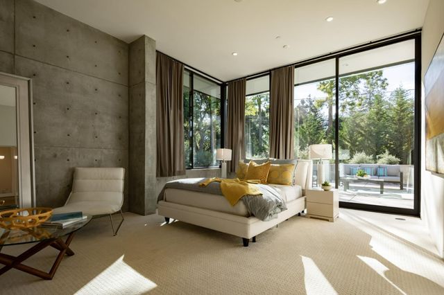a spacious bedroom with a bed and glass window