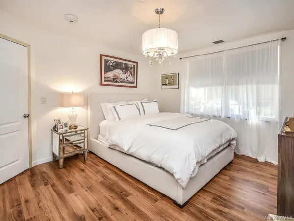 a bedroom with a bed and a chandelier