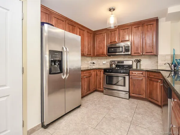 a kitchen with stainless steel appliances granite countertop a stove a refrigerator and a sink