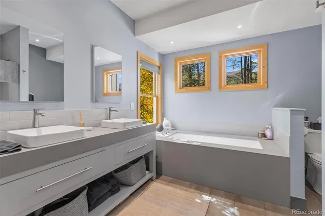 a bathroom with a tub a sink and mirror