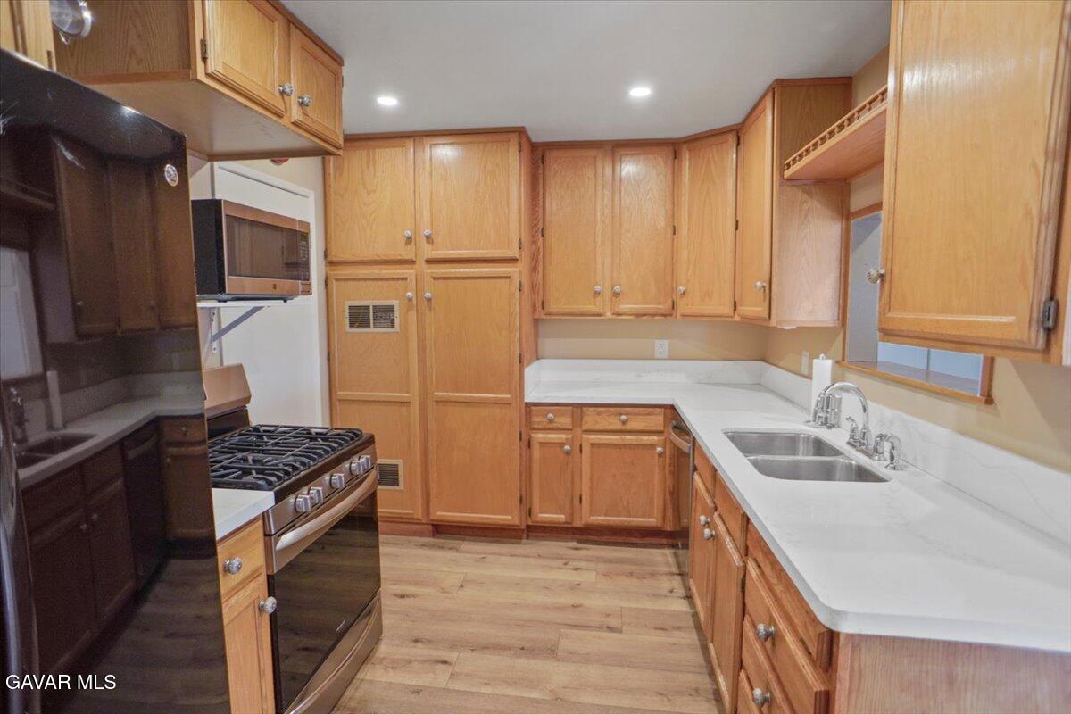 42652 55th Street West Lancaster, CA 93536 - Photo 11 of 28 a kitchen with stainless steel appliances granite countertop a sink stove and refrigerator
