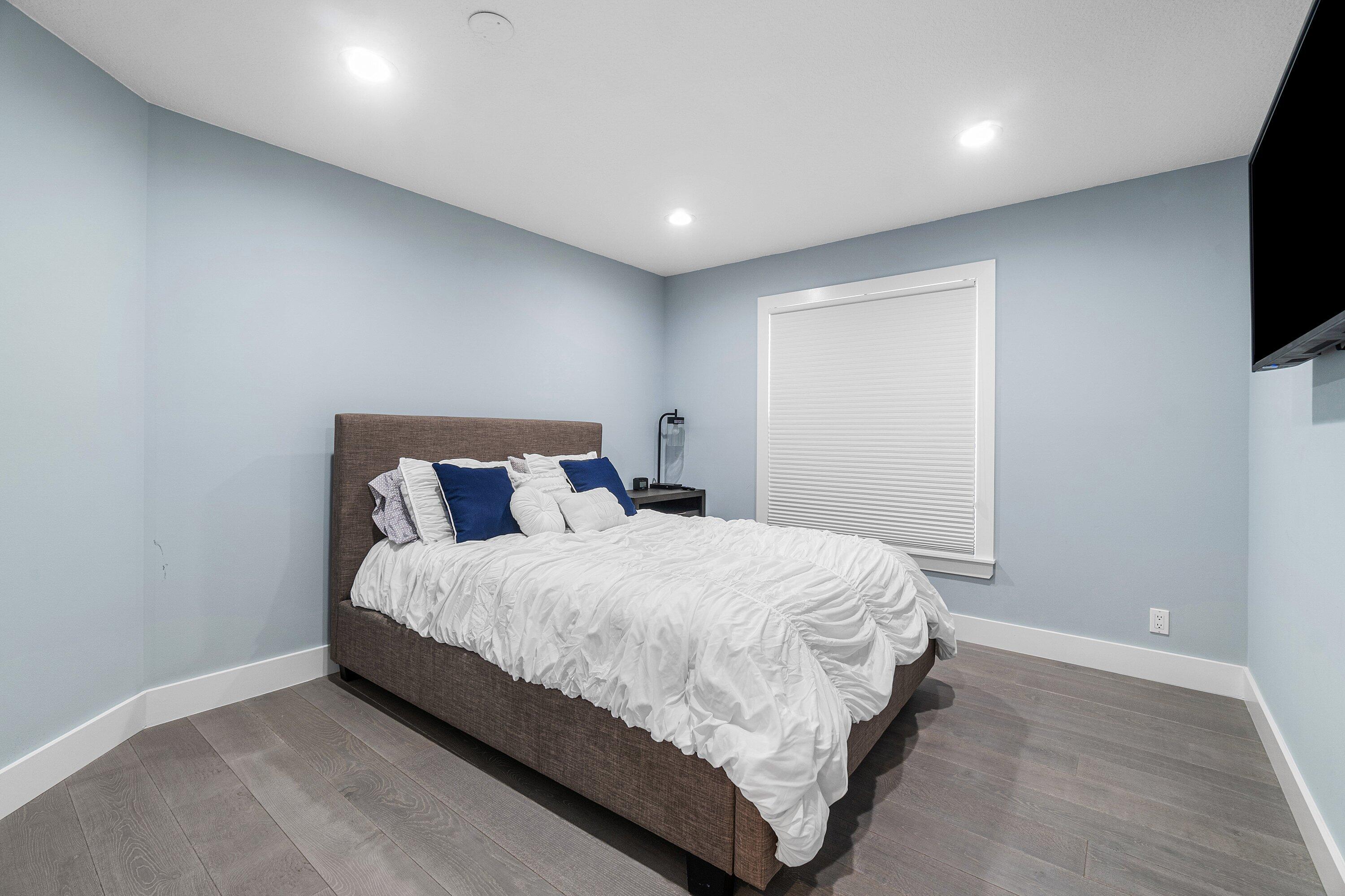 2404 Northwest 67th Street Boca Raton, FL 33496 - Photo 30 of 74 a large bed sitting in a room next to a flat screen tv