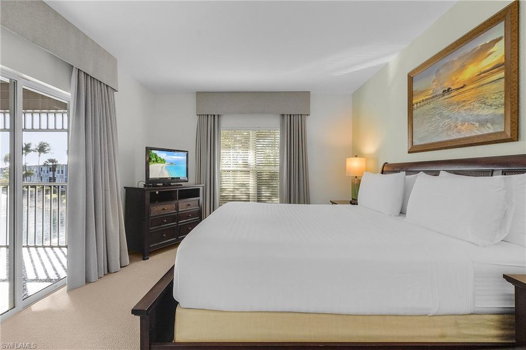 7870 Mahogany Run Lane, Unit 1724 Naples, FL 34113 - Photo 11 of 21 a bedroom with a bed and a large window with outer view