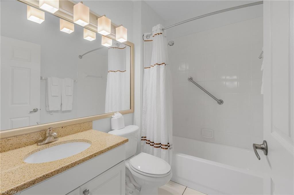 7870 Mahogany Run Lane, Unit 1724 Naples, FL 34113 - Photo 15 of 21 a bathroom with a granite countertop sink a toilet and shower