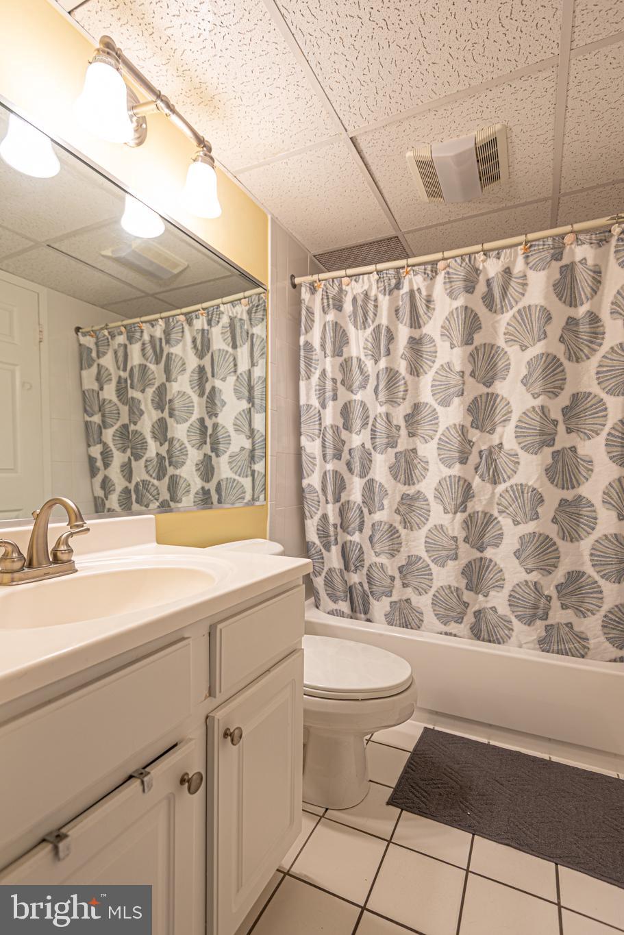 11700 Coastal Highway, Unit 1109 Ocean City, MD 21842 - Photo 18 of 50 a bathroom with a sink a toilet and shower curtain