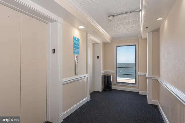 a view of an empty room with closet and a window