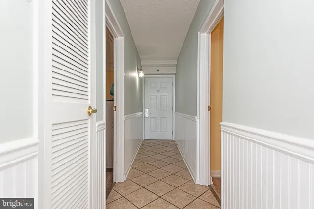 a view of a hallway with wooden floor and a bathroom