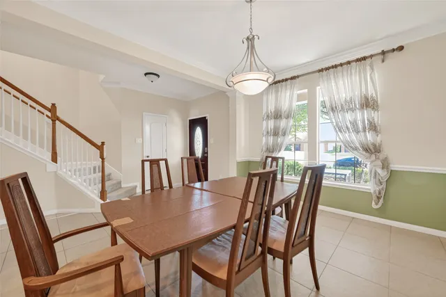 a kitchen with stainless steel appliances granite countertop a refrigerator a stove a sink a dining table and chairs with wooden floor