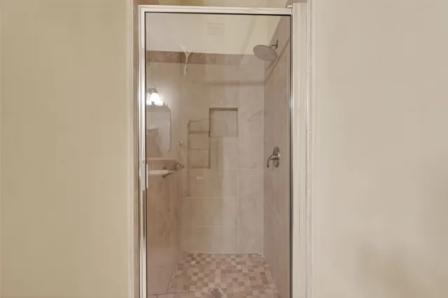 an empty room with wooden floor chandelier fan and windows