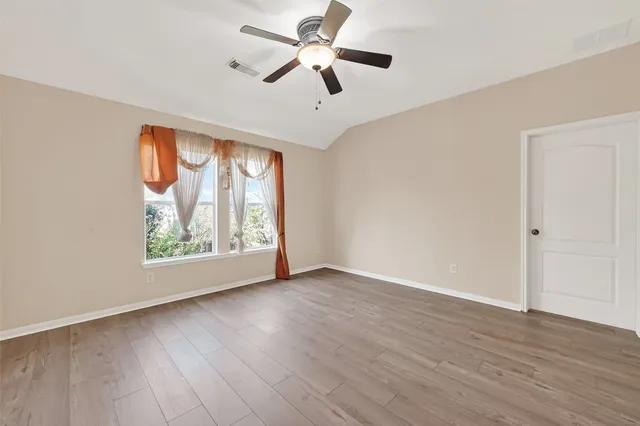 wooden floor in an empty room with a window