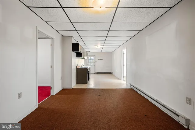 a view of a hallway with wooden floor and windows