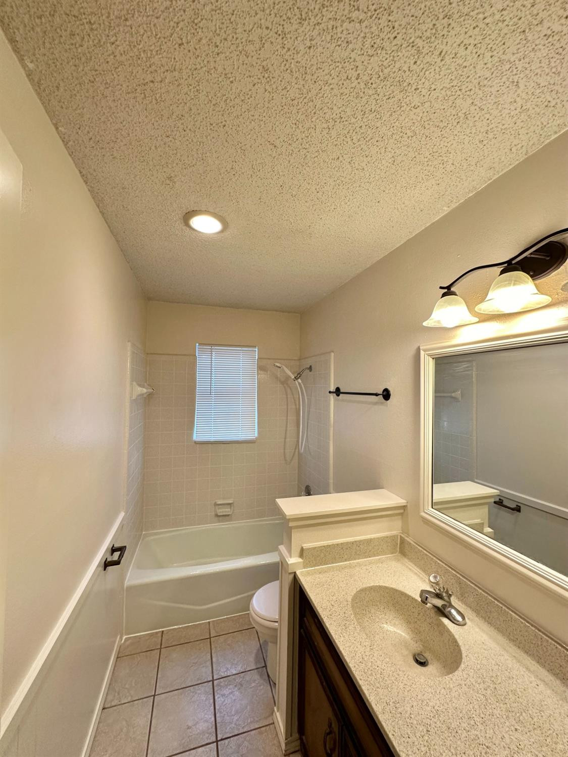 7805 Memphis Avenue, Unit B Lubbock, TX 79423 - Photo 7 of 13 a bathroom with a granite countertop sink toilet and shower
