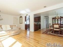 12 Ross Avenue Melville, NY 11747 - Photo 5 of 15 Living room featuring a chandelier and wood finished floors