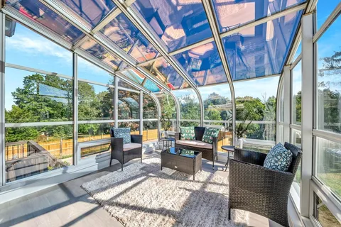 a living room with large windows and furniture