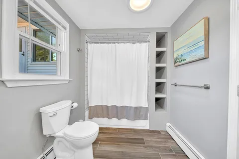 a bathroom with a toilet and a shower