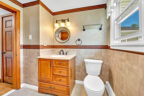 a bathroom with a toilet a sink and a mirror