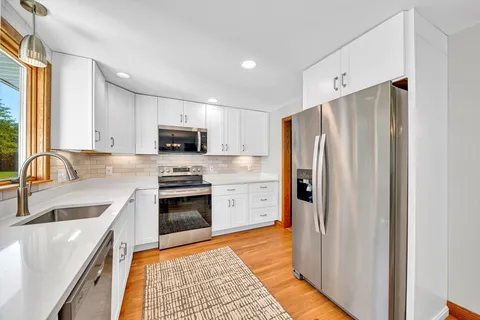 a kitchen with stainless steel appliances granite countertop a refrigerator stove and sink